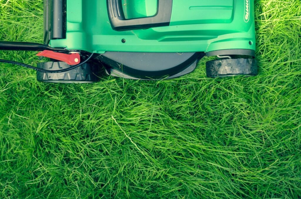 A lawn mower on a freshly mowed green lawn